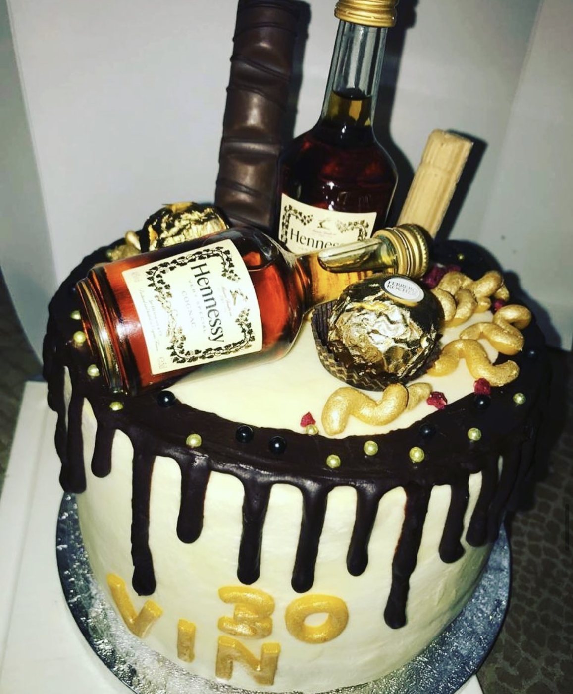 Driptaart met chocolade, gouden decoratie en flesjes cognac